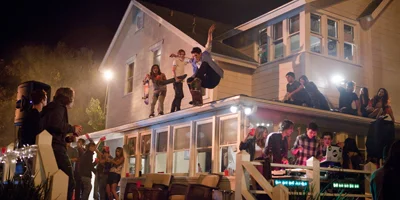 Guy on Skateboard Jumping Off Roof of House